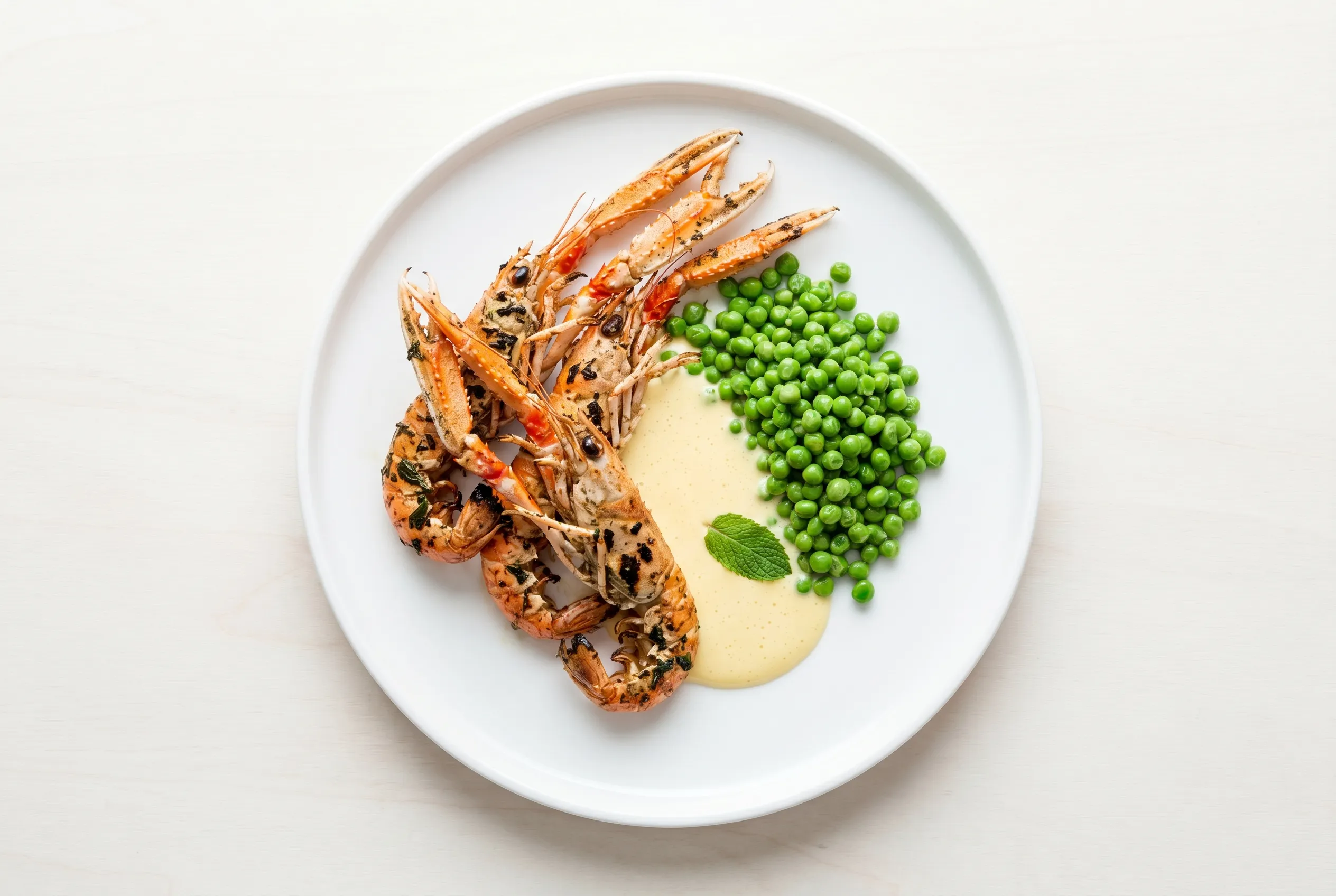 Langoustines rôties, petits pois à la menthe et sabayon léger