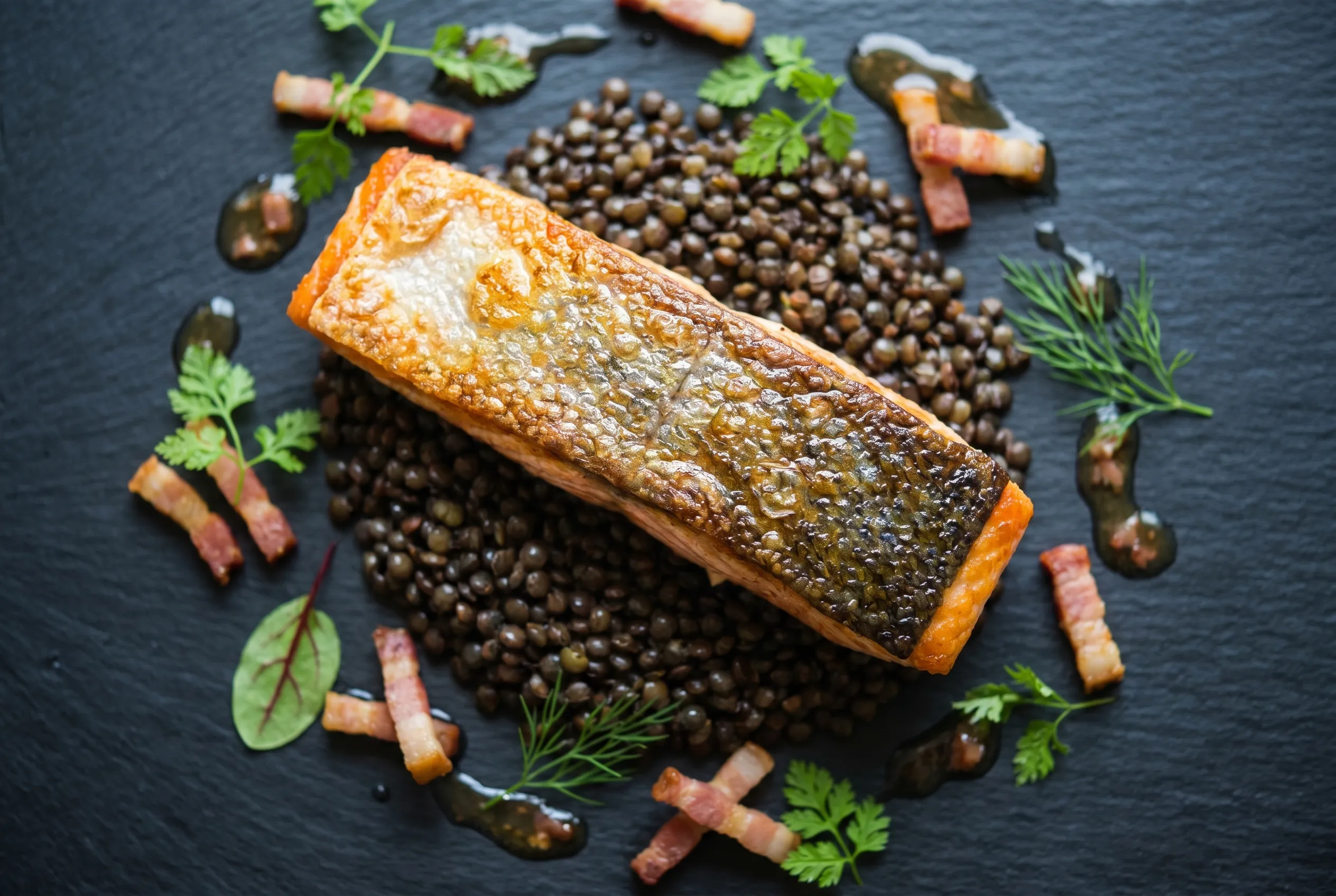 Pavé de saumon snacké, lentilles vertes et vinaigrette tiède au lard