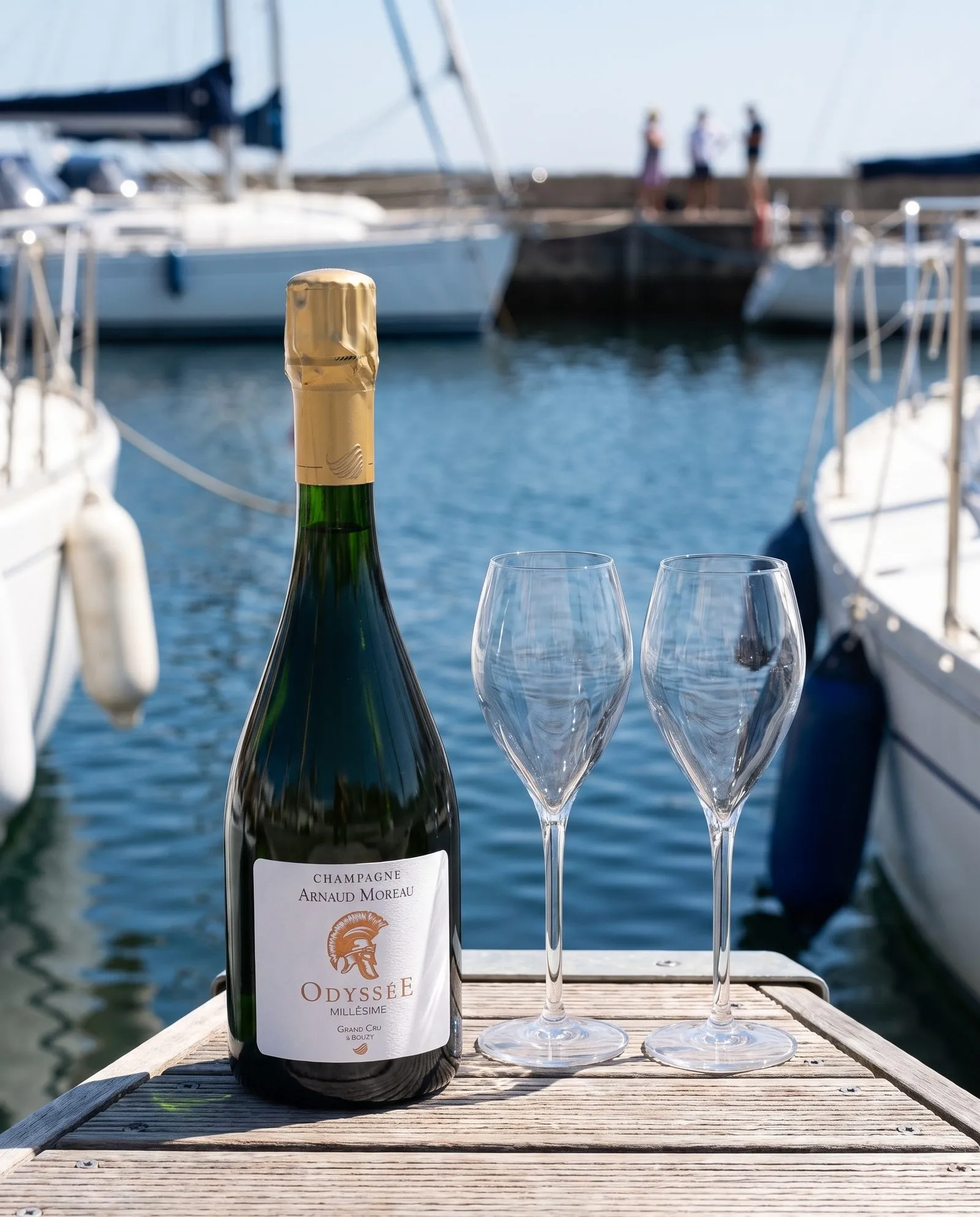 Champagne Arnaud Moreau Odyssée · sur un ponton, devant un voilier